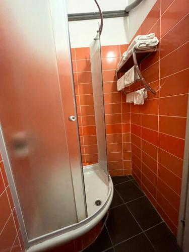 a shower with a glass door in a bathroom at The Only One Suites in Niš