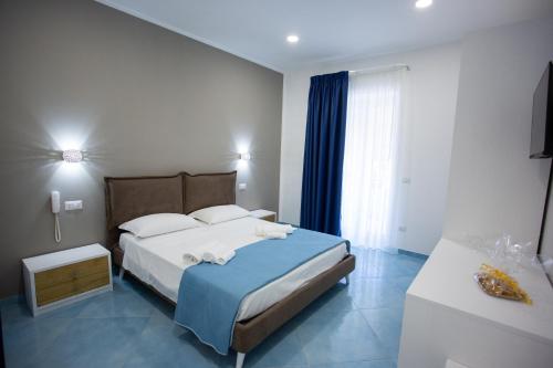 sypialnia z dużym łóżkiem i niebieskim kocem w obiekcie Hotel da Alfredo w mieście Castellabate