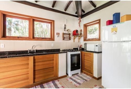 a kitchen with wooden cabinets and a white refrigerator at Tékinfin, você chegou! Lindo sítio em Secretário! in Petrópolis