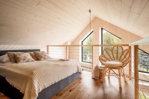 a bedroom with a bed and a chair in a room at Wy_spa_Podolany in Gdów