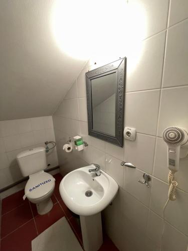 a bathroom with a sink and a toilet and a mirror at The Only One Suites in Niš