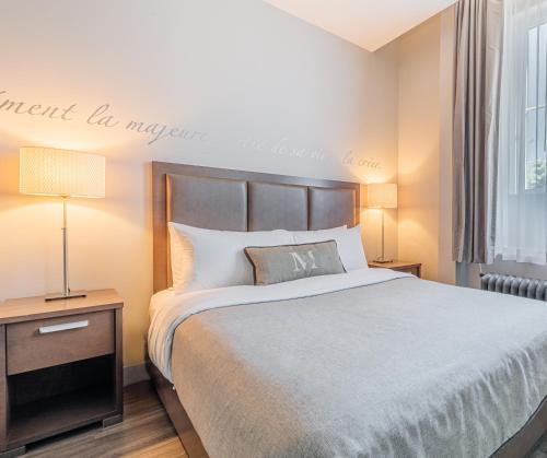 a bedroom with a large bed and a window at Hotel Montfort Nicolet in Nicolet