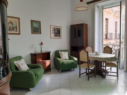 a living room with two green chairs and a table at Il Soffione Centro Storico in Salerno