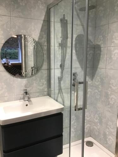 a bathroom with a sink and a shower with a mirror at Warlands Farm Guest House in Durham