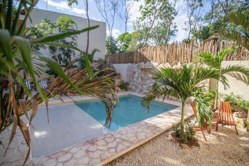 a swimming pool in a yard with a fence at Aldea San Lam - Oasis Of Tulum in Tulum