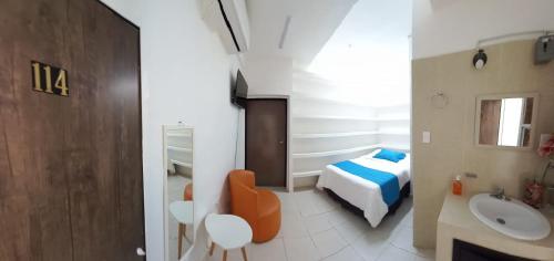 Habitación con baño con cama y lavabo. en Hotel boutique turquesa, en Tapachula
