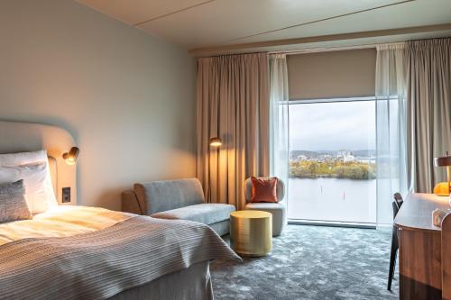 ヨーテボリにあるClarion Hotel The Pierのベッドと大きな窓が備わるホテルルームです。