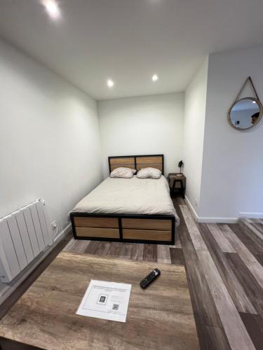 1 dormitorio con 1 cama y 1 libro en el suelo en Superbe appartement avec parking gratuit sur place, en Blanzy