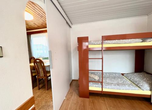 two bunk beds in a room with a table at Rodinná Chatka Mehes in Doksy