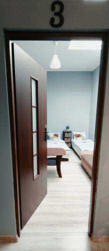 an open door to a room with two beds at Tanie spanie przy Malcie - Zameldowanie bezobsługowe - in Poznań
