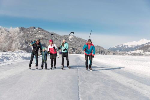 a group of people standing on the ice at Ferienhof Neusacher Moser in Weissensee