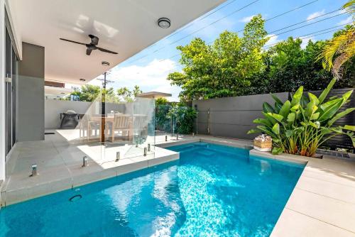 a swimming pool in the backyard of a house at Poolside Gunya Luxury Living in Fannie Bay in Darwin