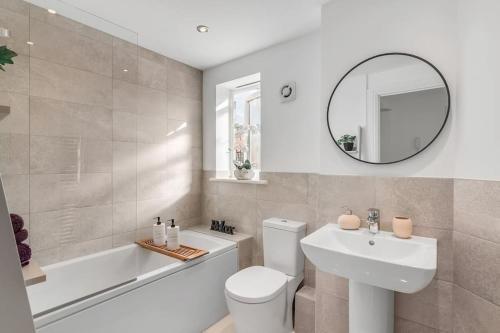 a bathroom with a toilet and a sink and a mirror at Modern Apartment in Wymondham in Wymondham