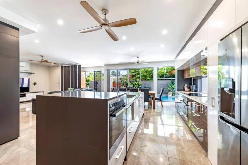 a kitchen with a ceiling fan and a dining room at Poolside Gunya Luxury Living in Fannie Bay in Darwin