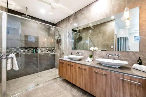 a bathroom with two sinks and a shower at Poolside Gunya Luxury Living in Fannie Bay in Fannie Bay