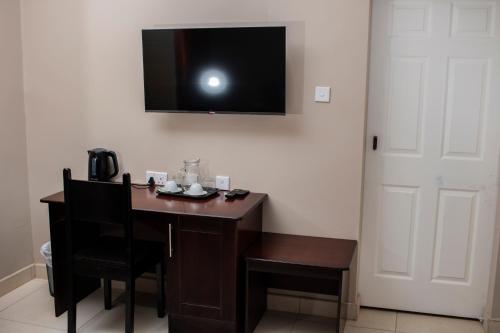 a room with a desk with a television on the wall at Pahotela Bed and Breakfast in Palatswe