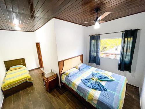 1 dormitorio con cama y ventana en Diniz Chacara, en Guaratinguetá