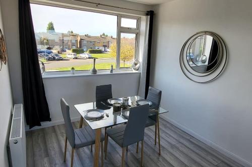 a dining room with a table and chairs and a mirror at Newly refurbished 3 bedroom flat in Bedworth