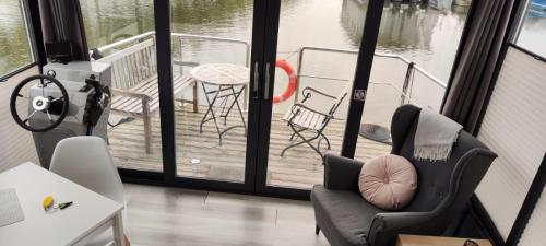 a room with a balcony with a chair and a table at Hausboot Lucky in Hattem