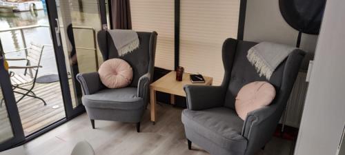 two chairs and a table in a room with a balcony at Hausboot Lucky in Hattem