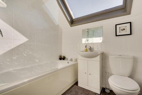 y baño con aseo, bañera y lavamanos. en Mews Cottage Arnside - 2 Bedroom Cottage, en Arnside