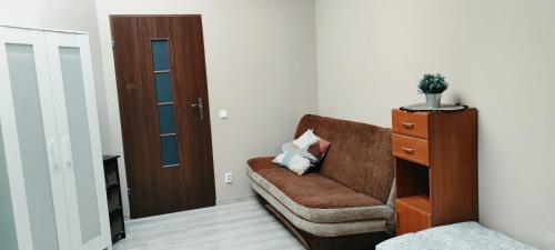 a living room with a brown couch and a door at Tanie spanie przy Malcie - Zameldowanie bezobsługowe - in Poznań