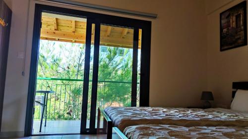 a bedroom with a bed and a large window at Limeria in Alona