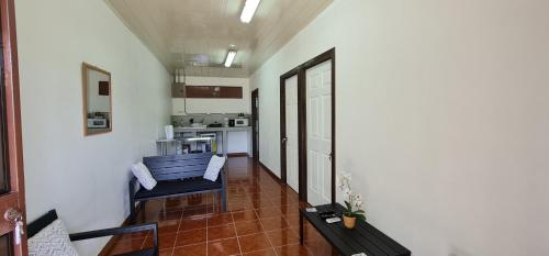a living room with two chairs and a kitchen at Sleep&Go! Apartamento de 2 habitaciones doble aire acondicionado en Siquirres in Siquirres