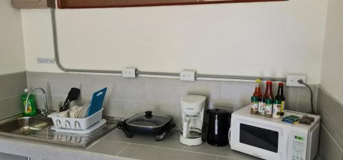 a kitchen counter with a microwave and a sink at Sleep&Go! Apartamento 2 habitaciones 4 personas Siquirres centro in Siquirres