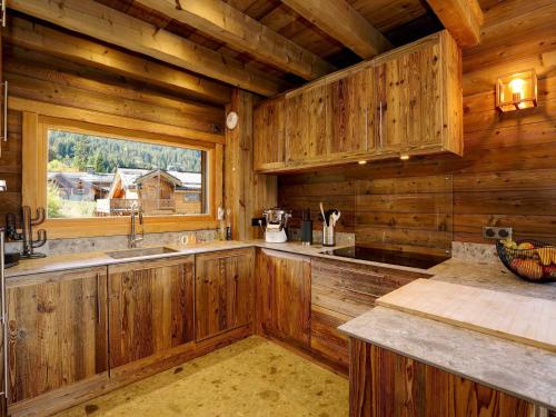 Il comprend une cuisine avec des murs en bois et une grande fenêtre. dans l'établissement Chalet d'Exception avec Sauna et Cheminée - 12 Pers, 6 Pièces - FR-1-575-32, à Courchevel