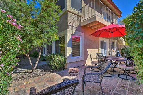 a patio with a table and chairs and a red umbrella at Resort-Style Gem with Pool Access 10 Mi to Dtwn PHX in Phoenix