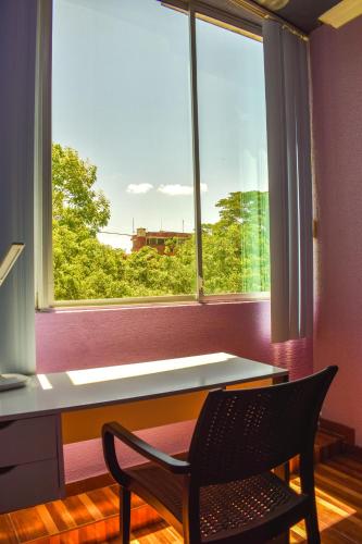 a desk and a chair in a room with a window at Hotel R Williams in Puerto Francisco de Orellana