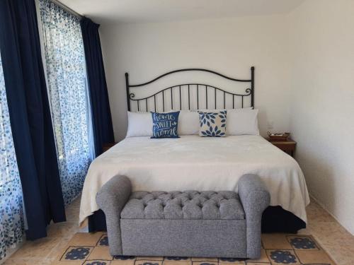 a bedroom with a bed and a couch and windows at Hotel Posada Santa Fe in Guadalajara