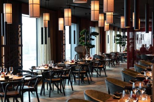 een eetkamer met tafels, stoelen en ramen bij Clarion Hotel The Pier in Göteborg