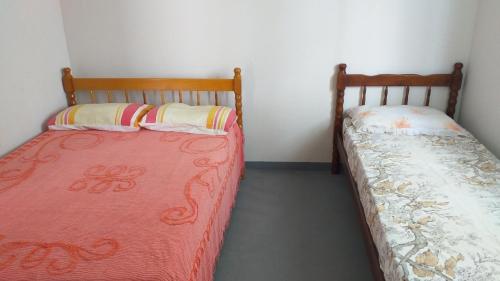 2 Betten nebeneinander in einem Zimmer in der Unterkunft valdemiro flores in São Francisco do Sul
