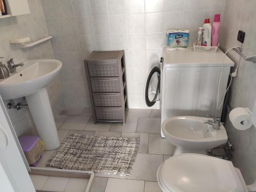 a bathroom with a toilet and a sink at Villa Cordella 3 in Patù