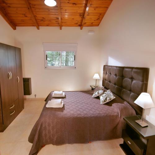 a bedroom with a large bed and a window at Altos del Rio (Solo parejas) in Los Reartes