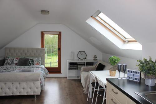cocina y dormitorio con cama y mesa en The Loft at Rock Cottage with hot tub, en Garvagh