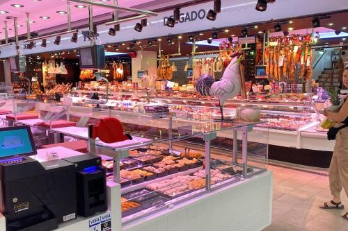 a woman standing in front of a display case in a store at La Pastora Apartamento con parking in Gavà