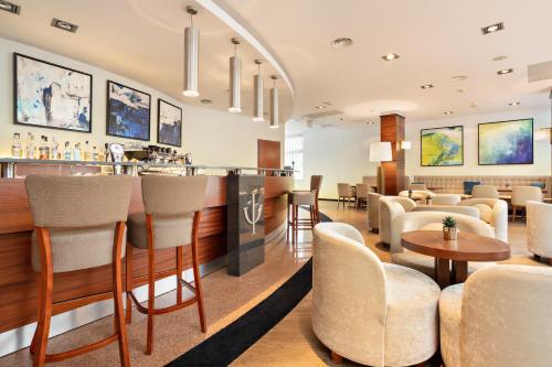 a hotel lobby with a bar and tables and chairs at Hotel Olympic Spa & Wellness in Ustroń