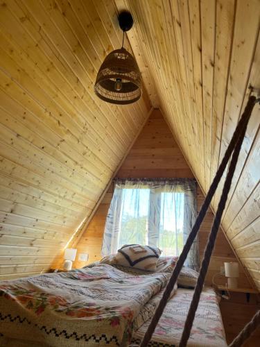 a bed in a tree house with a ceiling at Crângul Verde in Minciuneşti