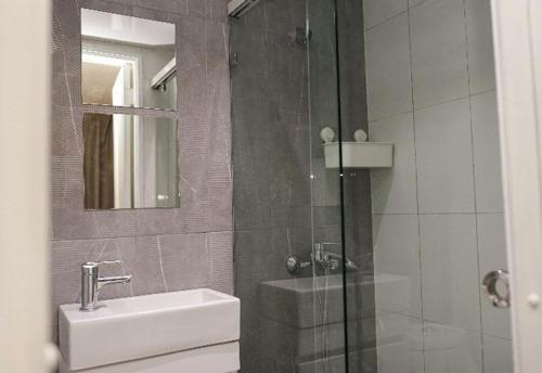 bagno con doccia, lavandino e specchio di Residencial Frank I a Santo Domingo