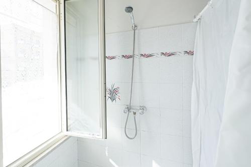 La salle de bains est pourvue d'une douche avec rideau de douche. dans l'établissement Seashore House - Appartamento a 100 mt dal mare, à Villafranca Tirrena