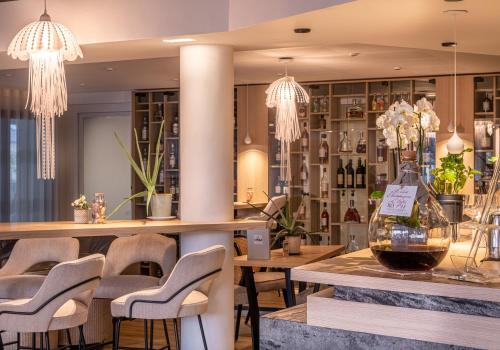 un bar avec des chaises et une table avec un vase de fleurs dans l'établissement Hostellerie de la Pointe Saint-Mathieu - SPA & Restaurant, à Plougonvelin