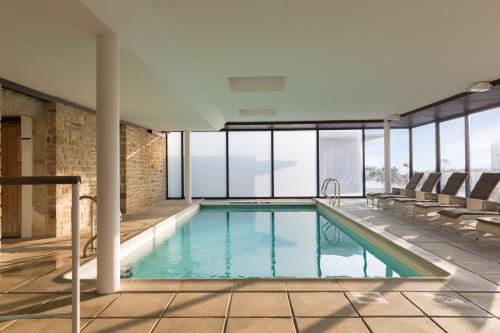 - une piscine dans un bâtiment avec fenêtres dans l'établissement Hostellerie de la Pointe Saint-Mathieu - SPA & Restaurant, à Plougonvelin