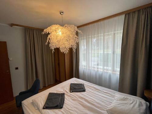 a bedroom with a white bed and a chandelier at "Winter" Apartment in Viljandi