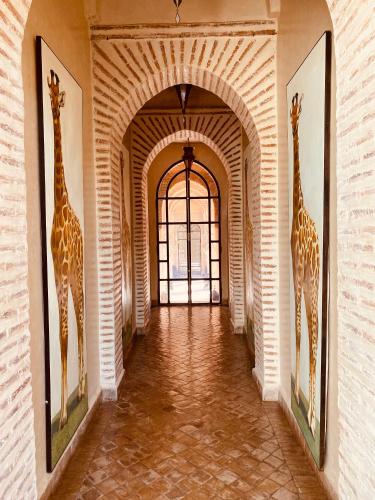two giraffes are standing in a hallway at Villa Serena Marrakech - Maison d'hôtes in Marrakech