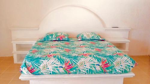a bed in a room with a colorful bedspread at Estudio con terraza y vista lago SUEÑOS DE ARENA in Casitas