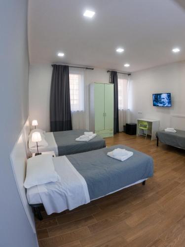 a hotel room with two beds and a couch at Hotel Bella Vita in Rome