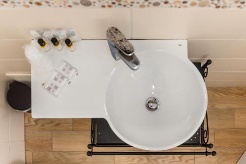 La salle de bains est pourvue de toilettes blanches et d'un lavabo. dans l'établissement Hotel Bella Vita, à Rome